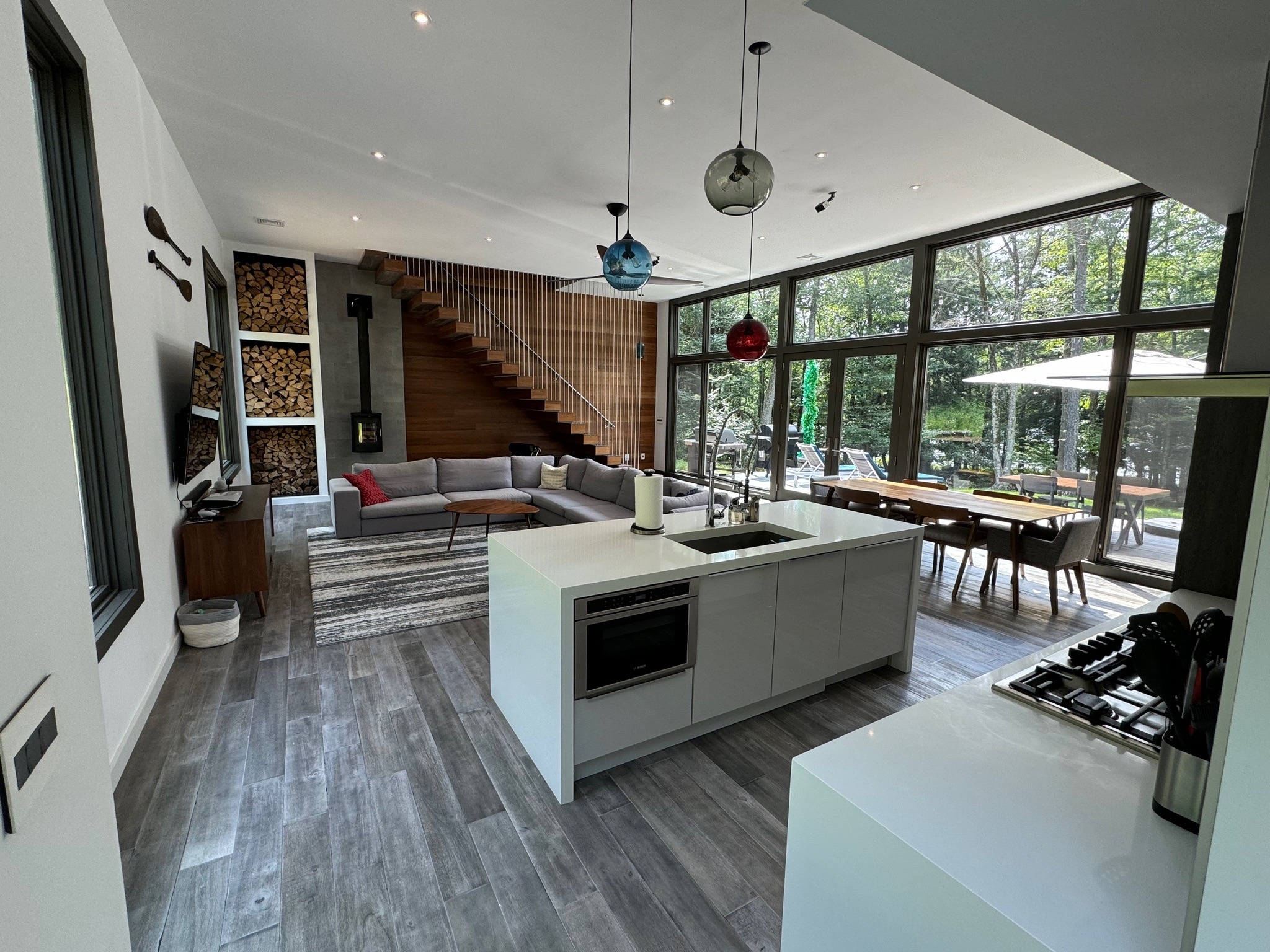 Airy modern lake house interior with organized open kitchen and living space